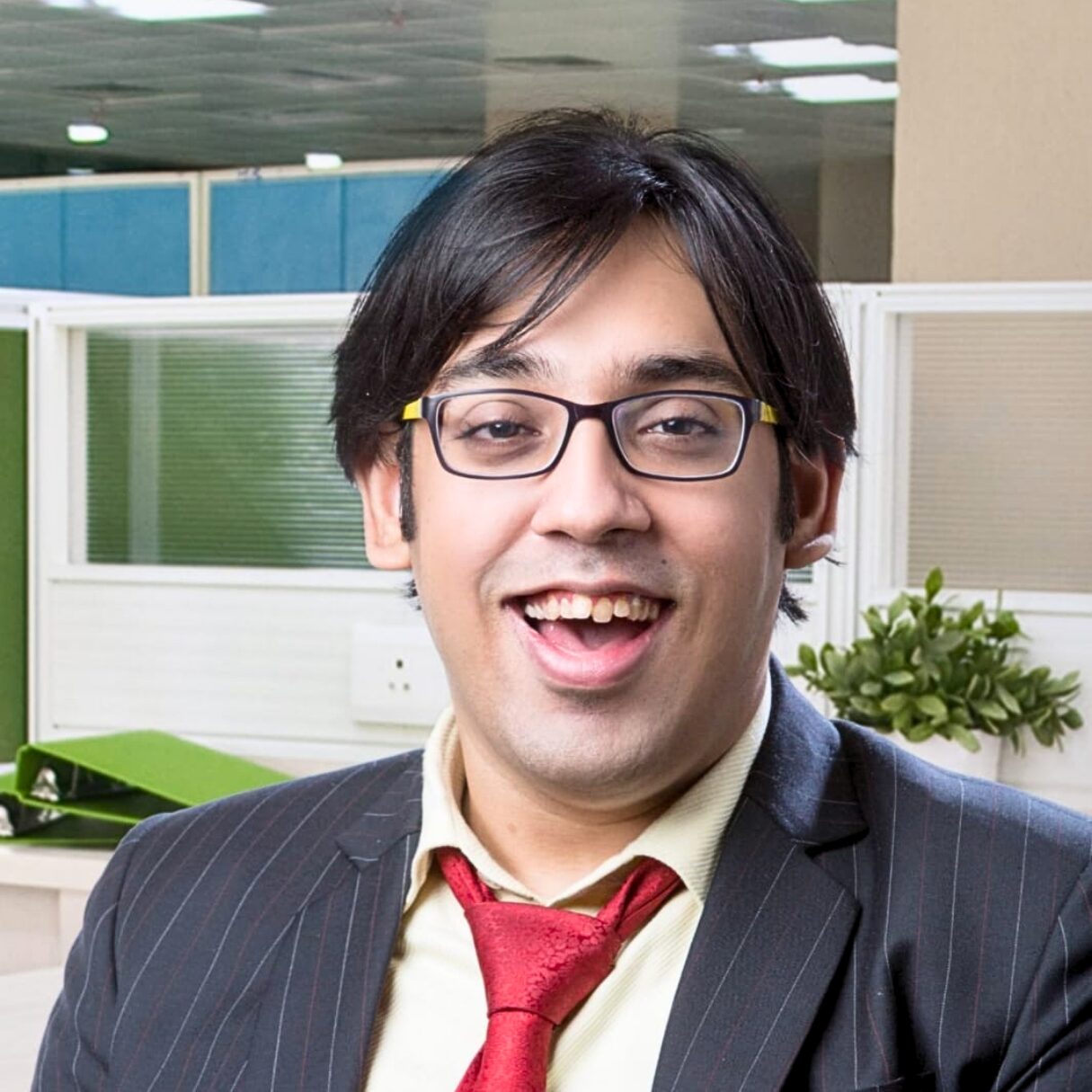 Sumit Agarwal, DEI expert and keynote speaker, smiling in a professional office environment
